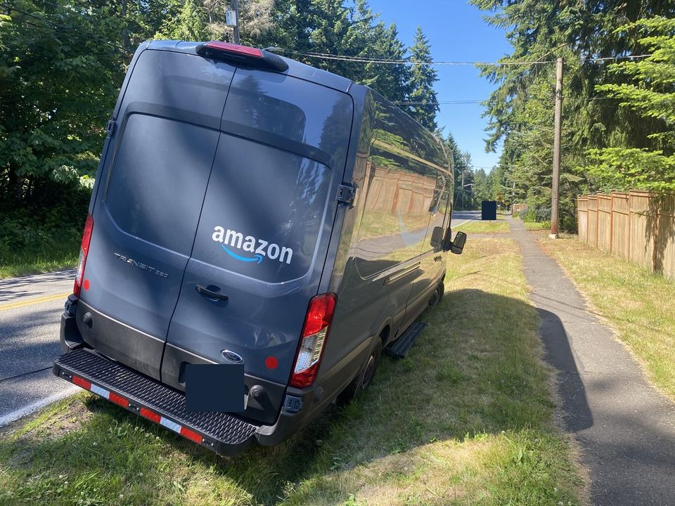 Delivery van tilted on the grassy roadside